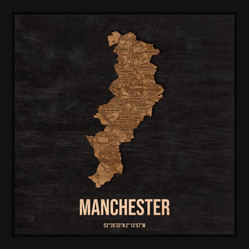 Drewniana mapa Manchesteru w ramce 25×25: kontur miasta na czarnej płycie, ulice, zabudowa, rzeki, granice i nazwy dzielnic