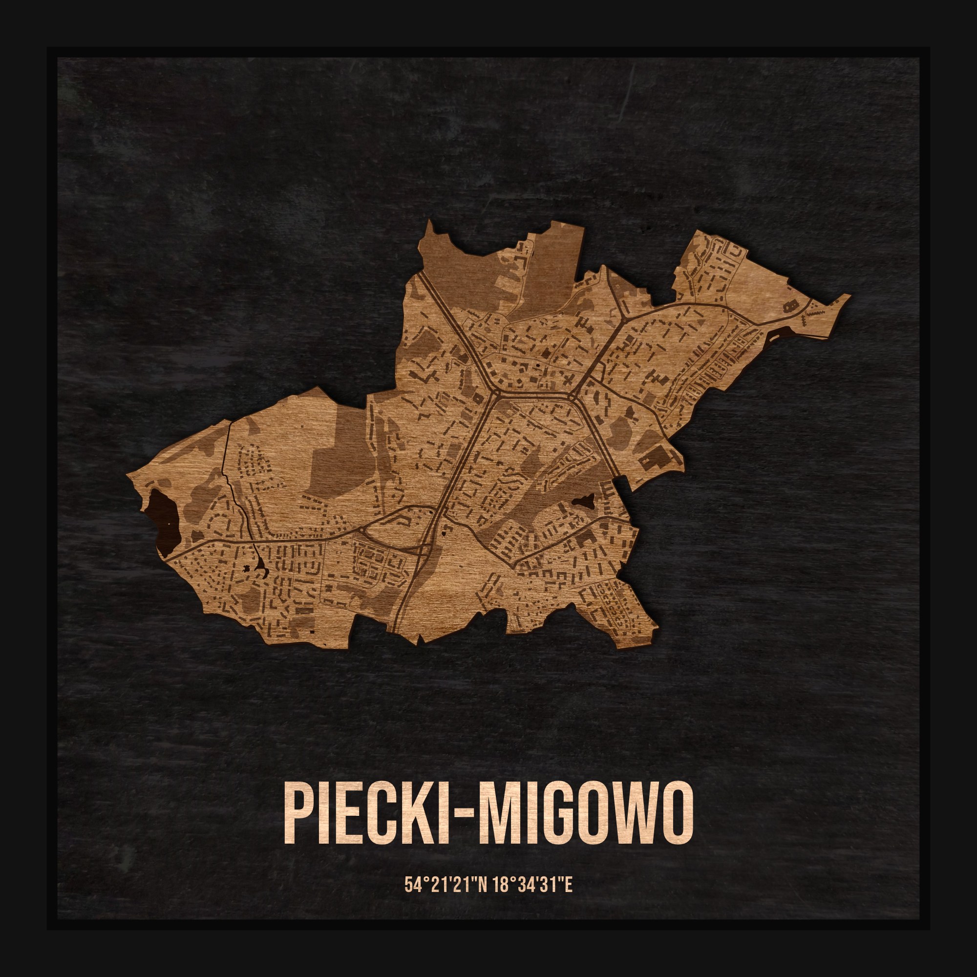 Drewniana mapa dzielnicy Piecki-Migowo w ramce 25×25: kontur dzielnicy na czarnej płycie, ulice, budynki, zieleń i woda